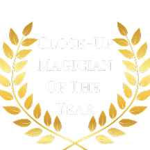Text graphic featuring the words "Close-Up Magician Of The Year" surrounded by a golden laurel wreath.