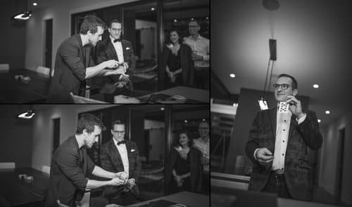A magician performs card tricks for a small audience in a stylish indoor setting.