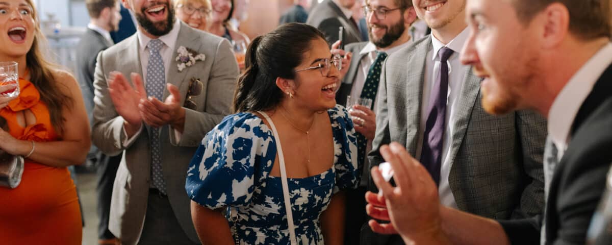 A group of people is gathered at a celebration, smiling and laughing.