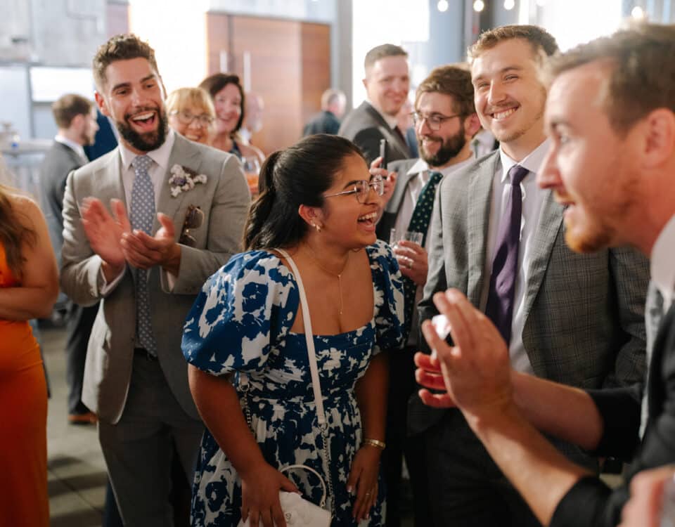 A group of people is gathered at a celebration, smiling and laughing.