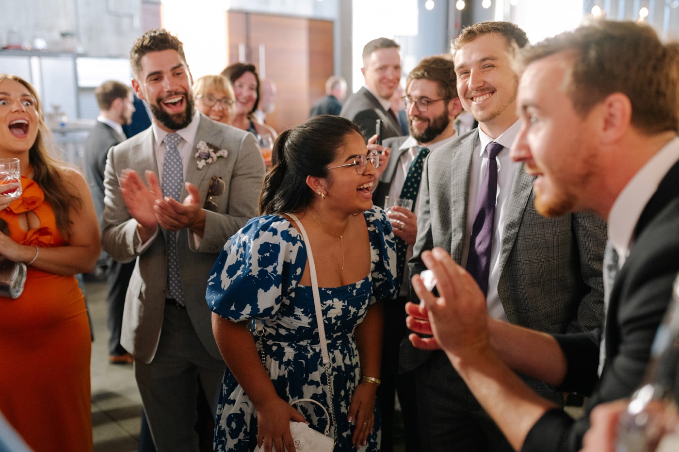 A group of people is gathered at a celebration, smiling and laughing.